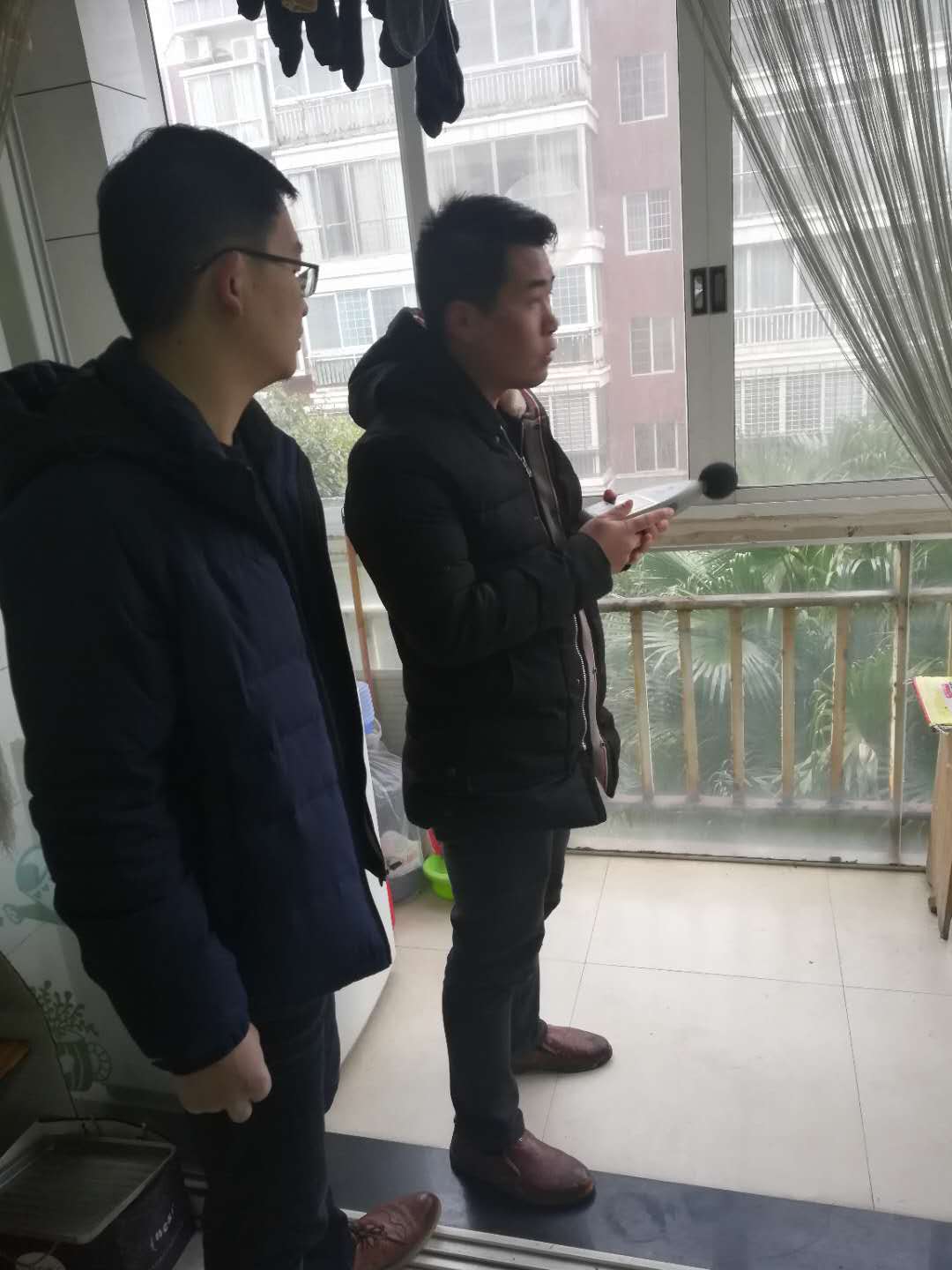 工作人员在居民家中测量噪音