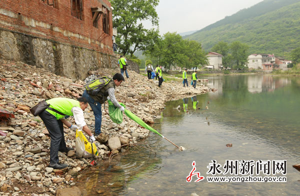 (环保志愿者正在对河面上的白色垃圾进行清理)